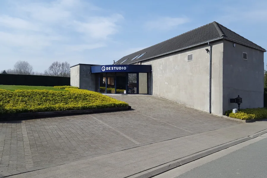De buitenkant van DESTUDIO in Asse, met het logo boven de ingang